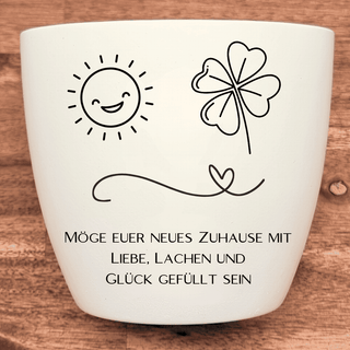 Weißer Blumentopf mit Sonne, Kleeblatt und Spruch "Möge euer neues Zuhause mit Liebe, Lachen und Glück gefüllt sein". Einz...
