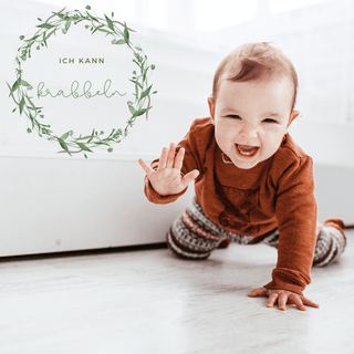 Lachendes Baby krabbelt. Meilensteinkarten "Ich kann krabbeln" von Naturmacher. Babys erstes Jahr.