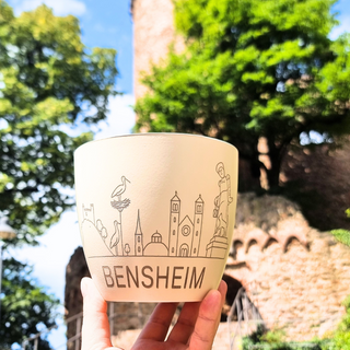 Keramiktopf mit Bensheim-Skyline, gehalten vor grüner Naturkulisse, von Natur Macher.