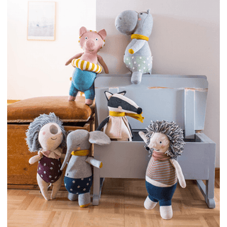 Stoffigel Kurt von ava&yves mit braunem gestreiftem Shirt und blauer Hose. Teil einer Gruppe von Stofftieren.