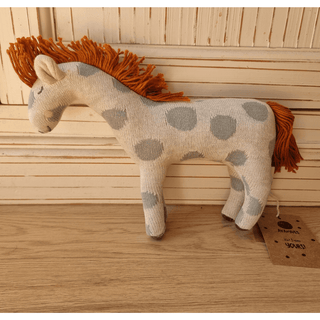 Kuschelige Ava & Yves Giraffe aus Strick mit grauen Punkten und oranger Mähne und Schweif. Baby- und Kinderspielzeug.