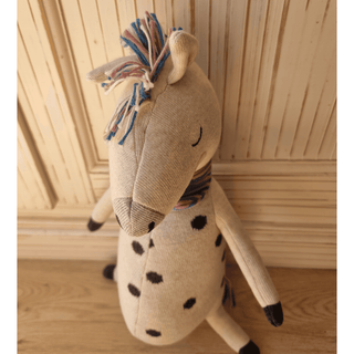 Kuscheltier Rainbow Horse von ava&yves aus Bio-Strick, beige mit schwarzen Punkten und bunter Mähne.