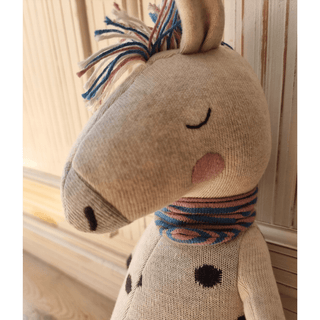 Kuschelpferd Rainbow Horse von ava&yves aus Bio-Strick, beige mit buntem Schal und Mähne.