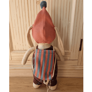 Stoffhase Alva von ava&yves, Rückseite mit rosa Mütze, gestreiftem Rucksack und braunem Latzhosenanzug. Kuscheltier für Ki...