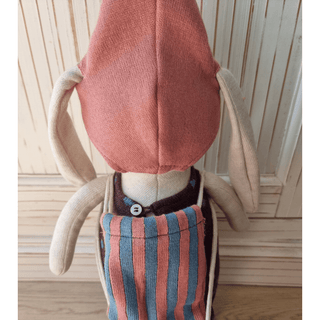 Kuschelhase Alva von ava&yves mit rosa Kapuze und blau-rosa gestreifter Latzhose, von hinten.