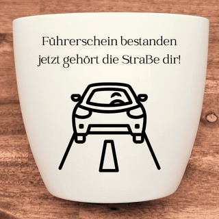 Weißer Blumentopf mit Aufdruck "Führerschein bestanden, jetzt gehört die Straße dir!" und Auto-Symbol. Abschlussgeschenk.