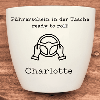 Weißer Blumentopf mit "Führerschein in der Tasche, ready to roll!" und Lenkrad-Symbol. Personalisiert mit "Charlotte". Füh...