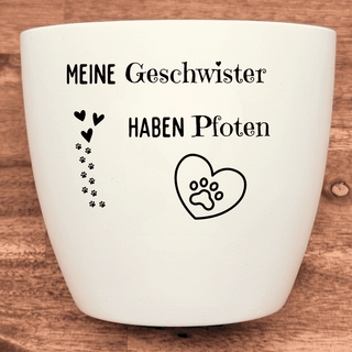 Weißer Blumentopf mit dem Aufdruck "Meine Geschwister haben Pfoten", Herz mit Pfotenabdruck und kleinen Herzen & Pfoten.
