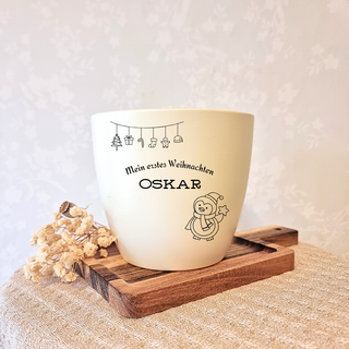 Beiger Blumentopf mit Gravur "Mein erstes Weihnachten Oskar" und Weihnachtsmotiven, ideal als Geschenk.
