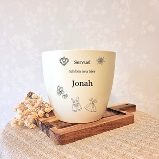 Beiger Blumentopf mit Gravur "Servus! Ich bin neu hier Jonah", Herz, Edelweiß und Trachtenmotiven. Personalisiertes Geschenk.