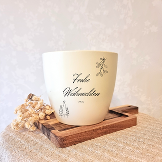 Beiger Blumentopf mit "Frohe Weihnachten 2025" Gravur, Mistelzweig und Tannenbaum-Motiv. Weihnachtsgeschenk von Natur Macher.