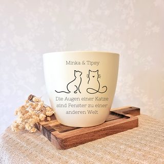 Beiger Blumentopf mit Gravur zweier Katzen und dem Spruch "Die Augen einer Katze sind Fenster zu einer anderen Welt". Pers...