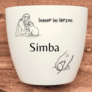 Weißer Blumentopf mit Gravur: Person umarmt Katze, "Immer im Herzen", Name "Simba", Hand hält Katzenpfote. Katzen-Erinneru...