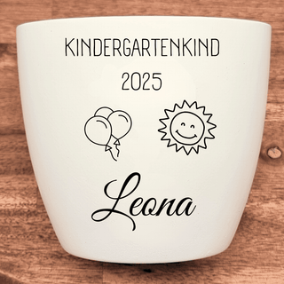 Weißer Blumentopf mit Gravur "Kindergartenkind 2025", Luftballons, lachender Sonne und dem Namen "Leona". Kindergarten Ges...