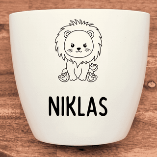 Weißer Blumentopf mit graviertem Löwen und dem Namen Niklas.