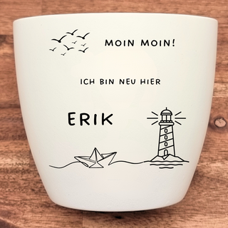 Weißer Blumentopf mit Gravur "Moin Moin", "Ich bin neu hier", "Erik", fliegenden Vögeln, Leuchtturm und Papierboot. Person...