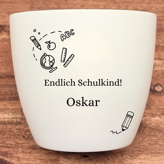 Weißer Blumentopf mit Einschulungsmotiv, graviert mit "Endlich Schulkind! Oskar". Geschenk von Natur Macher.