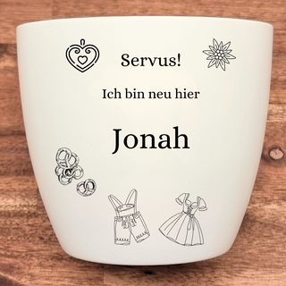 Weißer Blumentopf mit Gravur "Servus! Ich bin neu hier Jonah", Herz, Edelweiß, Brezeln und Trachtenkleidung. Personalisier...