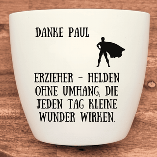 Weißer Blumentopf mit Superhelden-Motiv und Aufschrift "Danke Paul, Erzieher - Helden ohne Umhang". Abschiedsgeschenk Kita.