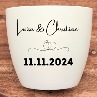 Weißer Blumentopf mit Gravur "Luisa & Christian", Ringen und Datum "11.11.2024". Hochzeitsgeschenk von Natur Macher.