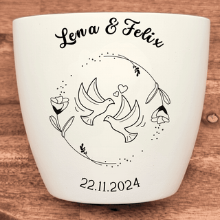 Weißer Blumentopf mit Gravur von zwei Turteltauben, Blumen und dem Datum 22.11.2024. Personalisiert mit "Lena & Felix". Ho...
