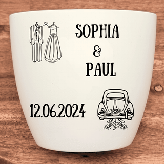 Weißer Blumentopf mit Gravur von Brautkleid, Anzug, Hochzeitsauto, "Sophia & Paul" und Datum "12.06.2024". Hochzeitsgesche...