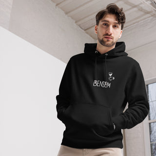 Schwarzer Eco-Hoodie von Naturmacher mit "BENSEM"-Aufdruck, getragen von einem Mann in modernem Raum.
