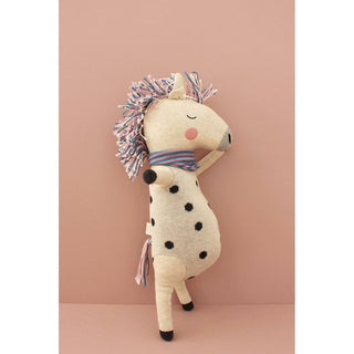 Kuscheltier Regenbogenpferd von ava&yves aus Bio-Strick, beige mit schwarzen Punkten, rosa-blauer Mähne und Schal.